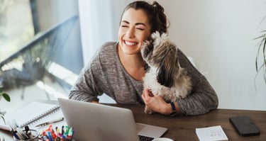 a woman sitting at a desk with a dog