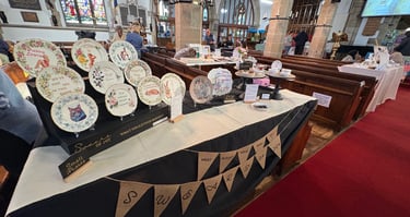 My first market with my vintage plates displayed on a stall at an indoor craft fair inside a church.