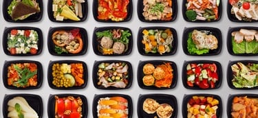 A wide variety of healthy meal prep containers with balanced salads, proteins, and fresh fruit.