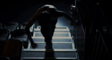 a man walking up stairs in a darkened room