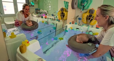 baby qui se regarde dans son bain et une bouée de cou à travers un grand miroir