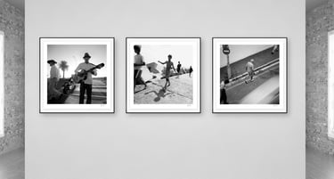 Three framed black-and-white photographs from Martin Osner’s On the Move collection displayed on a gallery wall.