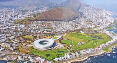 Aerial view of Cape Town Stadium and Table Mountain overlooking the South African coastline.
