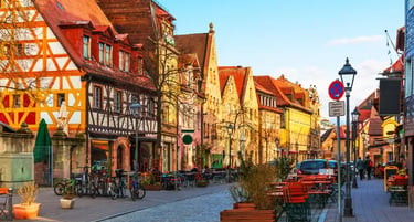Charming cobblestone street in Nuremberg Germany featuring historic timber-framed houses and outdoor cafes.