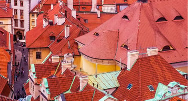Aerial view of historic red tiled roofs and narrow cobblestone streets in Prague's Old Town.