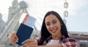 Smiling woman holding a blue passport and airline boarding pass in front of a white ferris wheel.