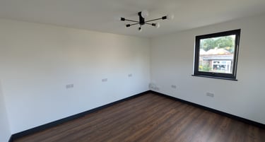 Plastered Garden Room with wood laminate flooring, white walls, and a black sputnik ceiling light.