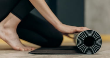 a person rolling up a yoga mat