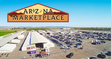 Aerial view of Arizona Marketplace in Yuma featuring outdoor flea market stalls and a large parking lot.