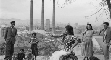 Una fotografía antigua en blanco y negro de una bailaora de flamenco frente a las tres chimeneas