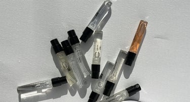 Una variedad de pequeños frascos de muestra de perfume esparcidos.