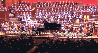 Photo of Steven Kings playing a grand piano in a concert hall