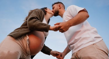 un couple s'embrasse tendrement lors d'une séance grossesse en couple sur la plage de la Paracou aux Sables d'Olonne