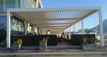 Pérgola bioclimática con mobiliario de exterior.