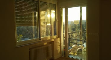 Ventanas de aluminio aislantes con luz tenue de atardecer.