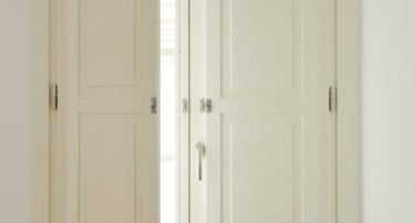 Ventana de madera blanca con contraventanas interiores.