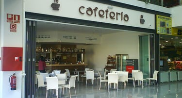 Cerramiento plegable en entrada a cafetería.