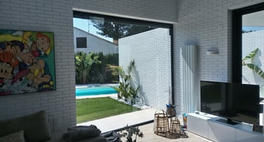 Fijo grande de aluminio lacado en negro mate. Piscina descubierta al fondo.