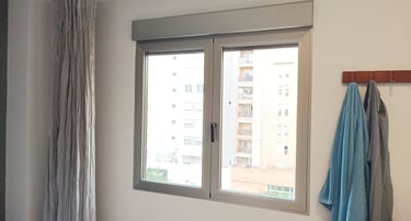 Ventana de aluminio plata con cajón de persiana.