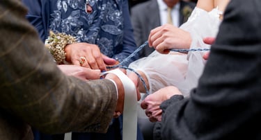 a bride and groomsmen are cutting their wedding cake