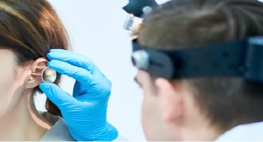 Otolaryngologist Dr. Porro uses a speculum and headlamp to perform a professional ear exam