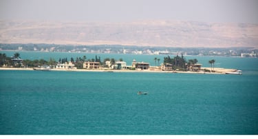 Vista de vilarejo a partir do navio no Canal de Suez com mar ao fundo