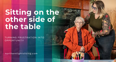 A caregiver comforts an elderly woman in a wheelchair by a fireplace, illustrating senior care services.