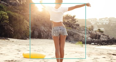 a woman standing on a beach with her arms up and arms outstretched out
