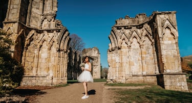 Bride walking between ancient stone arches in York, captured by Fred Art Studio.
