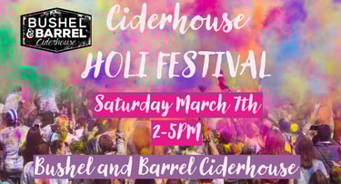 Crowd celebrating at the Bushel and Barrel Ciderhouse Holi Festival with colorful powder clouds.