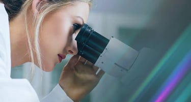 Health and biotech Investigator looking through a microscope