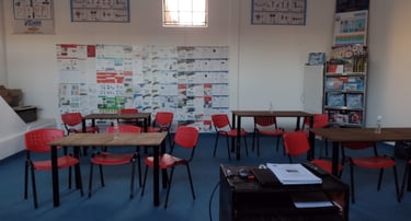 a classroom with desks and chairs and a desk , una de nuestras Aulas para los mejores cursos en CABA