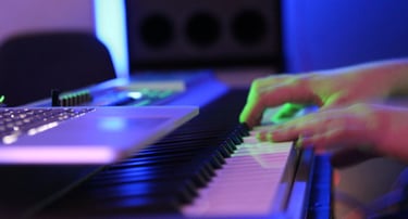 a person playing e-piano with a laptop