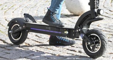a person riding a scooter on a cobblestone