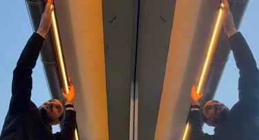 two men standing on a ladder ladder to reach up to the top of a building