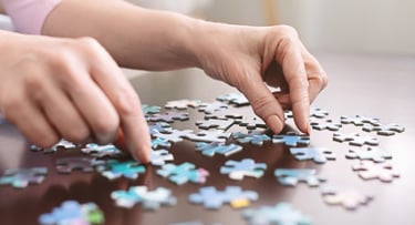 Two hands putting together a puzzle