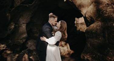a man and woman standing in front of a cave wedding photo