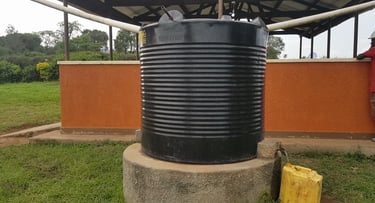 a black plastic water tank sitting on top of a cement block