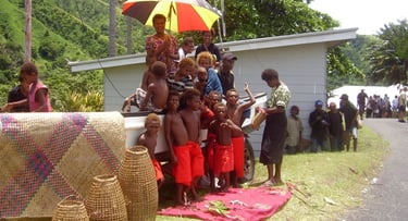 Cena local no porto de Rabaul com artesãos e crianças em barraca de artesanato típico da região.