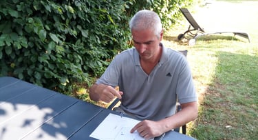 Le sourcier Philippe Maz assis avec un pendule