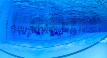 a group of people swimming in a pool mermaids gruppe von meerjungfrauen