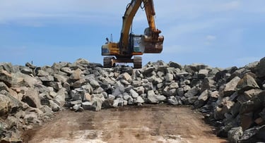 a large pile of rocks boulder and a bulldozer