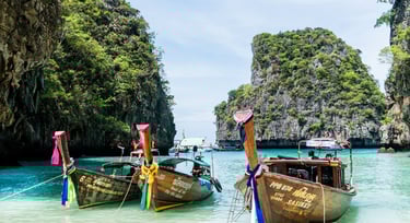 Barcos tradicionais tailandeses ancorados na Ilha Phi Phi, em Phuket, destino popular de cruzeiros pela Ásia