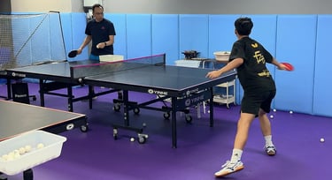 Advanced table tennis rally training with coach focusing on speed, footwork, and tactics
