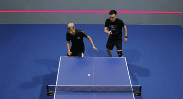 Senior table tennis coaching session supporting balance, mobility, and social connection