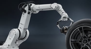 A robotic industrial arm working on a car wheel and tire assembly.