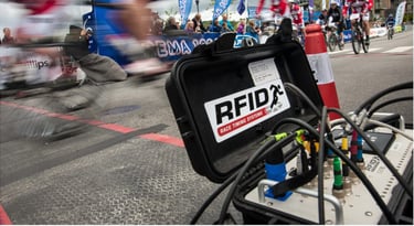 A photo of racers zooming by an RFID chip collection timing station in the midst of a race