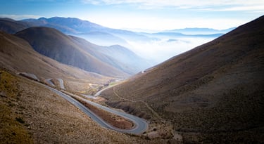 a winding road in the mountains with a view of the mountains