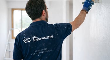 Peintre réalisant des travaux de peinture à l'intérieur d'une maison