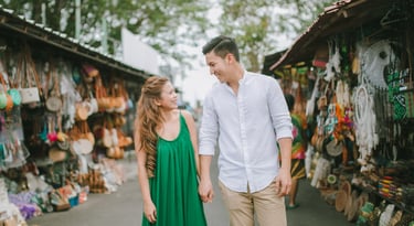 Couple walking through local market area near Tanah Lot Bali during an intimate photography session.
